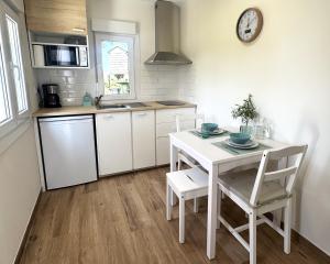 a white kitchen with a white table and chairs at A de Silva, apartamento accesible en As Cortiñas in Coens
