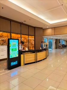 a lobby of a hotel with people at a counter at Shell Residences MOA - Josh staycation in Manila +46 photos