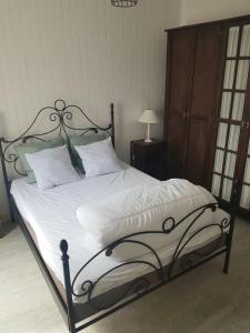 a bed with a black frame and white sheets and pillows at la brise marine in Saint-Hilaire-de-Riez