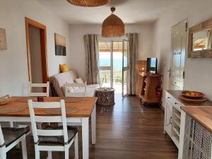 kuchnia i salon ze stołem i krzesłami w obiekcie Tarifa-Blick auf Afrika, Haus am Meer, Haustiere erlaubt w mieście Tarifa