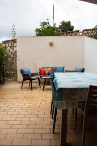 un patio con tavolo, sedie e parete di Custonaci Addisio Home a Custonaci
