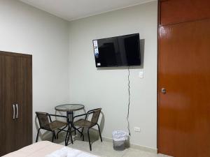 a room with a table and a tv on the wall at Mablia Suite in Ica +16 photos