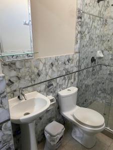 a bathroom with a sink and a toilet and a mirror at Mablia Suite in Ica +16 photos