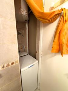 a small kitchen with a refrigerator and a curtain at Acapulco Beach in Costa de Adeje