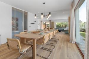 a dining room with a long table and chairs at - Villa Alizee - Luxe en charme in pittoresk De Haan in De Haan