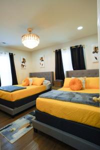 due letti in una stanza con un lampadario di Modern Luxe Retreat -Heart of Chesterfield a Richmond
