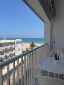 a balcony with a table and chairs and the beach at Precioso estudio completo en 1º linea in Puerto de Gandía