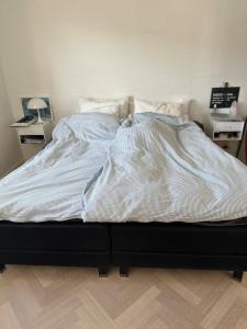 1 cama no hecha en un dormitorio con 2 mesitas de noche en Beautiful gem in a quiet setting, en Svendborg