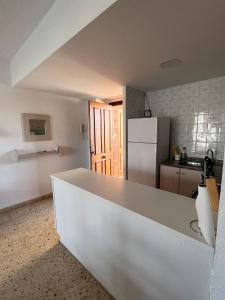 a kitchen with a white counter and a refrigerator at Precioso estudio completo en 1º linea in Puerto de Gandía
