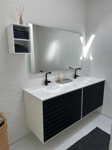 un baño con lavabo y espejo en Beautiful gem in a quiet setting, en Svendborg