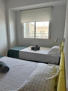 two beds in a room with a window at Precioso estudio completo en 1º linea in Puerto de Gandía