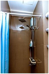 a shower in a bathroom with a blue curtain at 2 bedroom fantastic air condo 3649 swim gym surf 300 MB in Manila