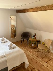 a bedroom with a bed and a chair and a table at Hiestand's Gästehaus - Weingut & Hofbrennerei in Guntersblum