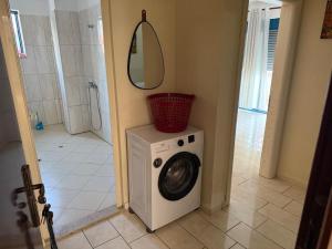 a washing machine in a bathroom with a shower at Golem Villa Ap 1 First Floor in Golem