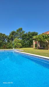 a large blue swimming pool in front of a house at Villa Gomes Pedro in Tomar