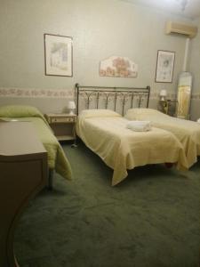 a bedroom with two beds with green comforters at AmbraBed Lunghezza Station in Lunghezza +25 photos