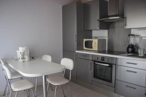 a kitchen with a white table and white chairs at Villa Yoda in Saint-Jean-de-Luz