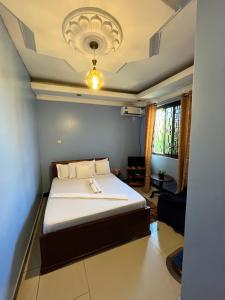 a bedroom with a bed with a ceiling at Stay In Style Lodge in Dar es Salaam