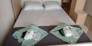 a bed with two pairs of shoes on it at Downtown Hub 2 in Alexandroupoli
