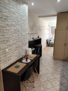 a living room with a table and a brick wall at Downtown Hub 2 in Alexandroupoli +9 photos