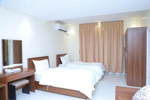 a hotel room with two beds and a desk at سما المملكة للشقق المخدومة- اقتصادي in Riyadh