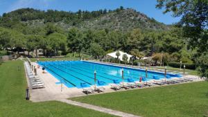 a large swimming pool with chairs and a mountain at Villetta Roberto Le Macine di Charme - Pugnochiuso Resort in Vieste