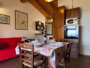 Dimora Cala-Vista في توري دي كورساري: مطبخ مع طاولة وأريكة حمراء