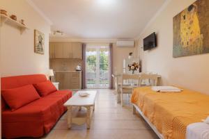 a living room with a red couch and a kitchen at Villa Caterina in Ýpsos