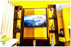 a living room with a tv and a yellow wall at 2 Bedroom Green Yellow luxury 5549 Makati 300Mb swim in Manila