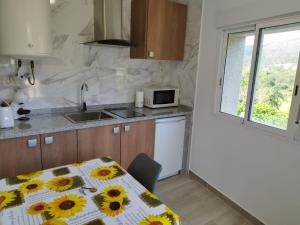 una cucina con tavolo e girasoli di Casa do Corgo a Bubaces