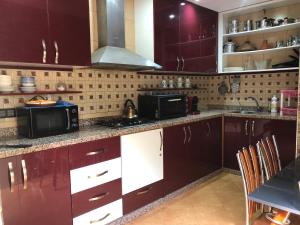 a kitchen with dark purple cabinets and appliances at Dar LALA NEJMA in Marrakesh