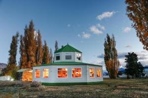 a house with a green roof on a field at Estancia Cristina Lodge - El Calafate in Estancia Cristina