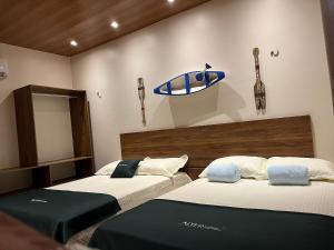 two beds in a room with a surfboard on the wall at Casa Vista da Ilha in Alter do Chao +24 photos