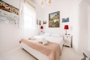una camera da letto bianca con due letti e una finestra di Hotel Delfines a Mykonos Città
