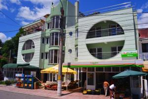 a building on a street with people standing in front of it at Pensiunea Meridian in Eforie Nord