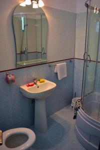 a bathroom with a sink and a toilet and a mirror at Pensiunea Meridian in Eforie Nord