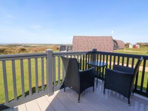a balcony with two chairs and a table on it at Starfish Rock in Bude +7 photos