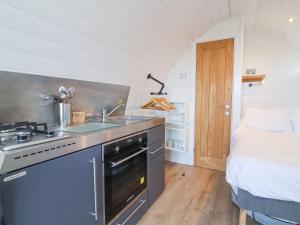 a kitchen with a stove and a sink and a bed at Starfish Rock in Bude