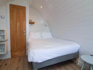 a bed in a small room with a wooden door at Starfish Rock in Bude