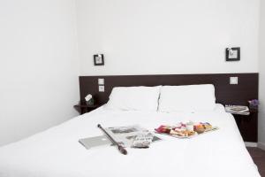 een wit bed met een dienblad met eten erop bij At Home Appart Hotel in Toulouse