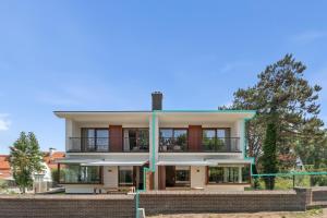 a house on a hill with trees in the background at - Villa Adonis - Luxe en charme in pittoresk De Haan in De Haan