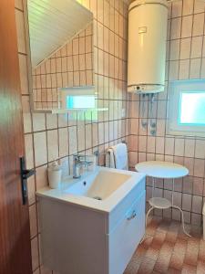 a small bathroom with a sink and a table at Apartmani Mirko App in Molat