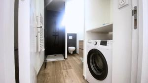 a bathroom with a washing machine in a room at Havre de paix au cœur de la ville in Ay