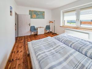 a bedroom with a bed and a desk and a window at De lütt Dörpkieker am Torgelower See in Torgelow am See
