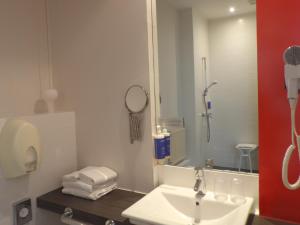 a bathroom with a sink and a shower at Hôtel De La Vallée in Dinard