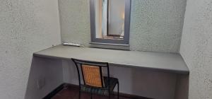 a counter with a chair sitting under a mirror at Boabab at Greenway Woods in White River