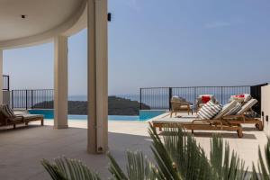 a patio with lounge chairs and a view of the ocean at Villa Astoria Dubrovnik in Dubrovnik
