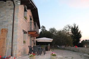 a patio with chairs and an umbrella next to a building at Baita del bosco in Laino