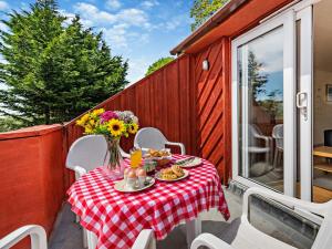 a table with a vase of flowers on a patio at 2 Bed in Amroth 94789 in Pembrokeshire