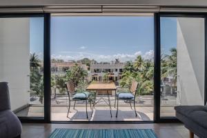 a dining room with a table and chairs on a balcony at Vela's Condos Ocean Front in Puerto Morelos
